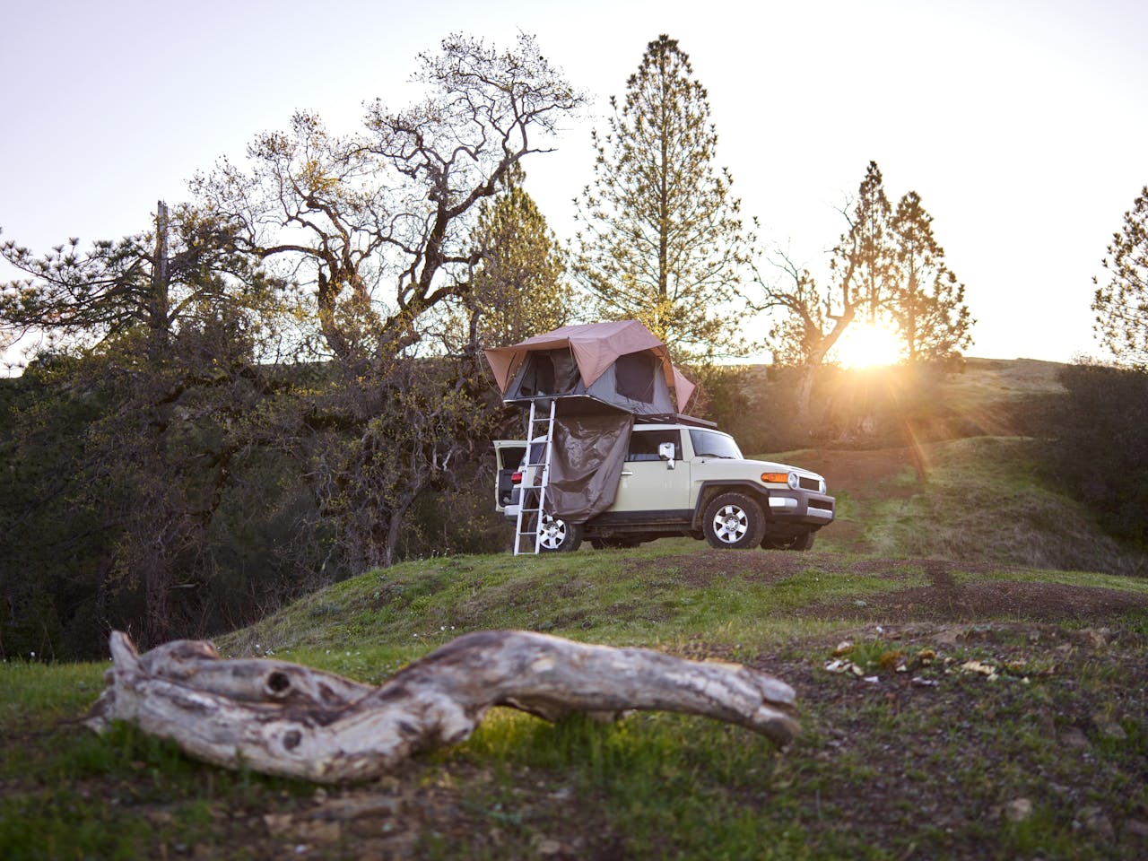 about-02 Experience a serene camping evening with a rooftop tent on an SUV in the picturesque wilderness.